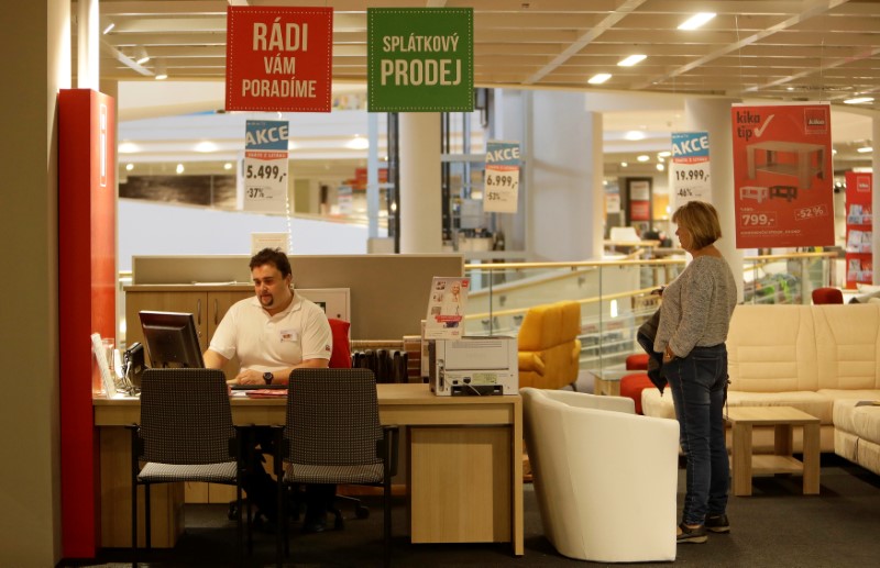 © Reuters. A shop assistant offers an instalment sale to a customer inside of Kika furniture store chain in Prague