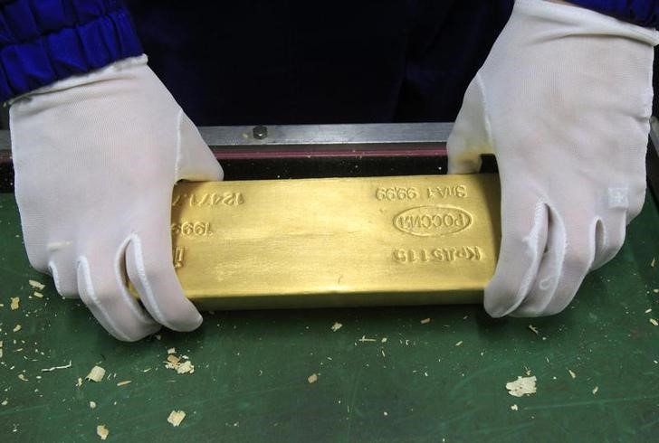 © Reuters. Служащий ЦБР держит слиток золота