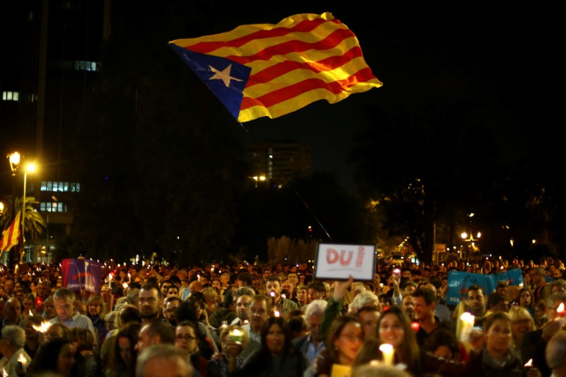 © Reuters. People wave Esteladas during a gathering to protest against the imprisonment of leaders of two of the largest Catalan separatist organizations who were jailed by Spain's High Court, in Barcelona