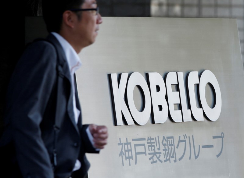 © Reuters. FILE PHOTO: A man walks past the signboard of Kobe Steel at the group's Tokyo headquarters in Tokyo