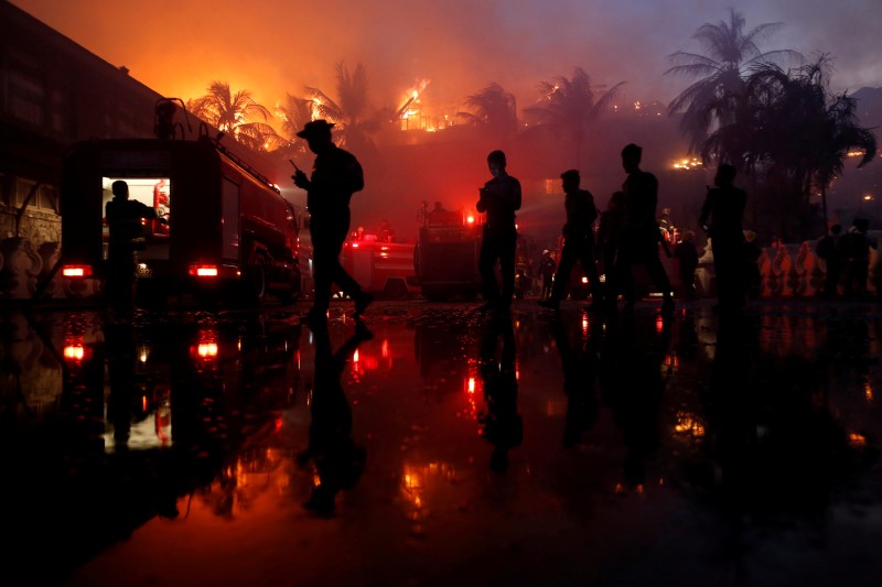 © Reuters. Police officers stand guard during a fire at Kandawgyi Palace hotel in Yangon, Myanmar