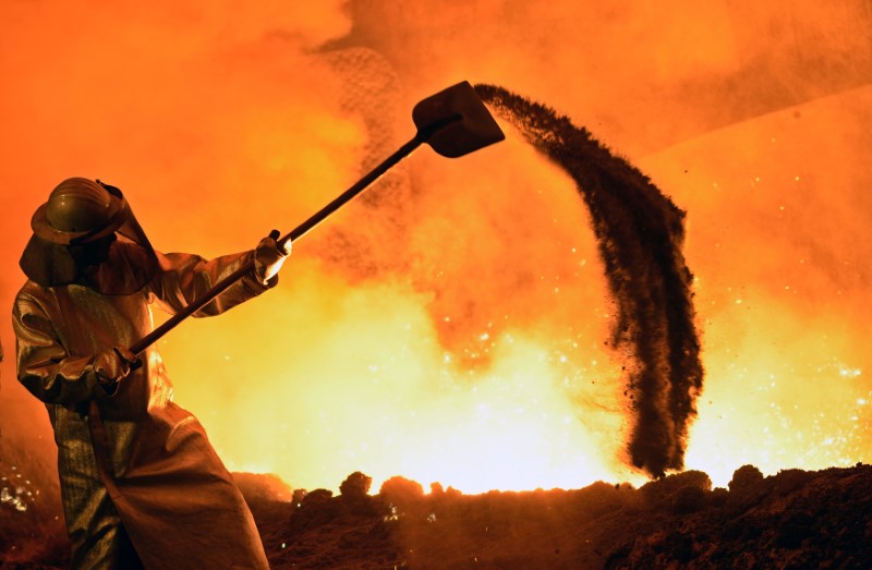 © Reuters. FILE PHOTO: A steel-worker is pictured at a furnace at the plant of German steel company Salzgitter AG in Salzgitter