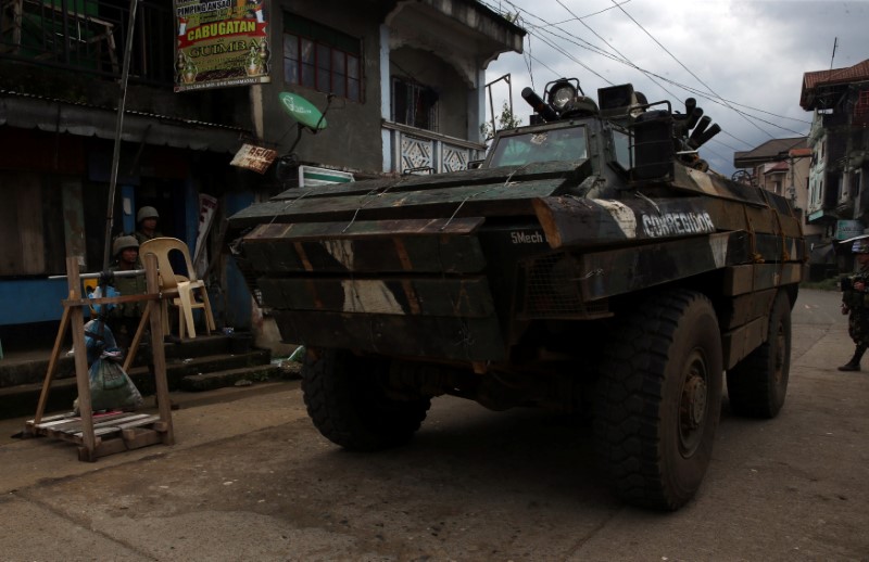 © Reuters. An APC drives past at a military checkpoint after government troops cleared the area from pro-Islamic State militant groups inside the war-torn Marawi city