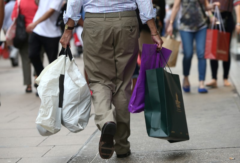 © Reuters. FILE PHOTO: Shoppers carry bags in London