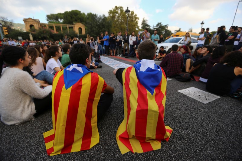 © Reuters. Estudantes vestem bandeira separatista da Catalunha durante protesto em Barcelona, Espanha