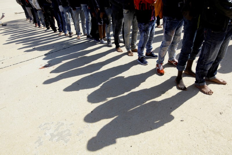 © Reuters. Migrants stand at naval base after they were rescued by Libyan coastguard, in Tripoli