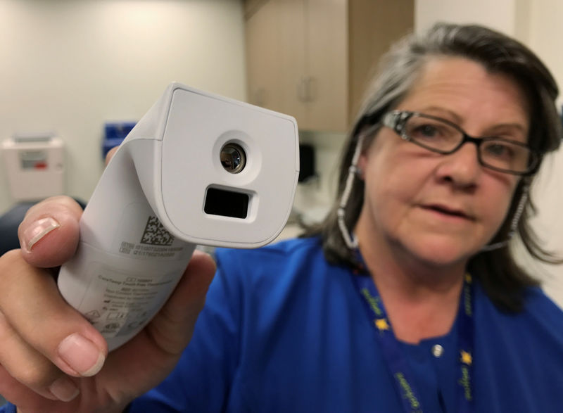 © Reuters. Registered nurse Tara McCormick, Clinical Services Manager, demonstrates an infrared thermometer at West Virginia University Hospital in Morgantown