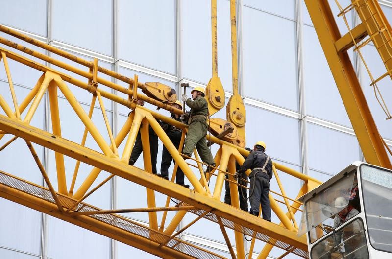 © Reuters. Labourers work at a construction site in Beijing's central business area