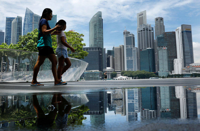 © Reuters. FILE PHOTO: People pass the skyline of Singapore