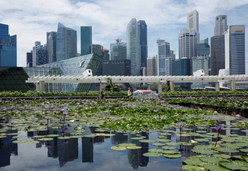 © Reuters. FILE PHOTO: People pass the skyline of Singapore