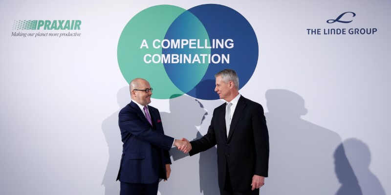 © Reuters. Praxair CEO Angel and Linde CEO Belloni shake hands at news conference in Munich