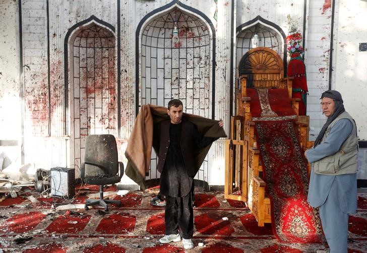 © Reuters. Мужчины в шиитской мечети Кабула после взрыва