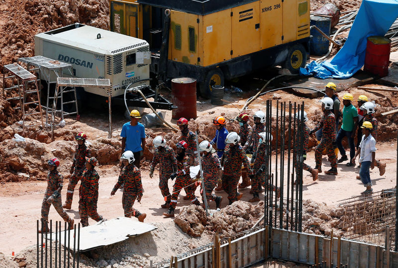 © Reuters. Rescue workers carry the body of a landslide victim at a construction site in Tanjung Bungah, a suburb of George Town