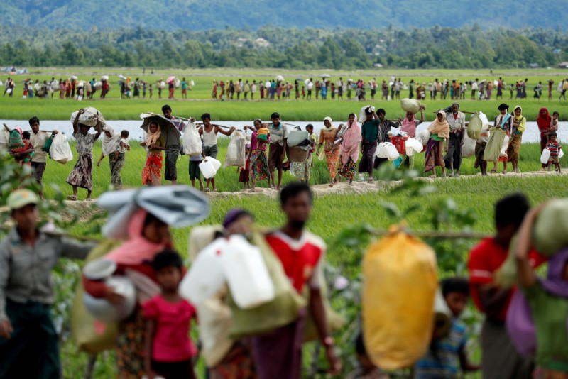 © Reuters. FILE PHOTO: Rohingya refugees, who crossed the border from Myanmar two days before, walk after they received permission from the Bangladeshi army to continue on to the refugee camps, in Palang Khali