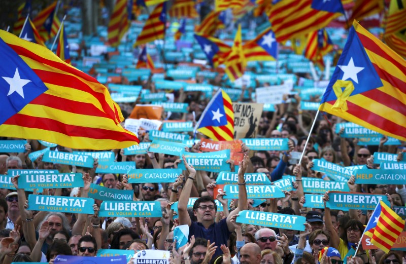 © Reuters. People wave separatisy Catalan flags and placards during a demonstration organised by Catalan pro-independence movements ANC (Catalan National Assembly) and Omnium Cutural, following the imprisonment of their two leaders in Barcelona
