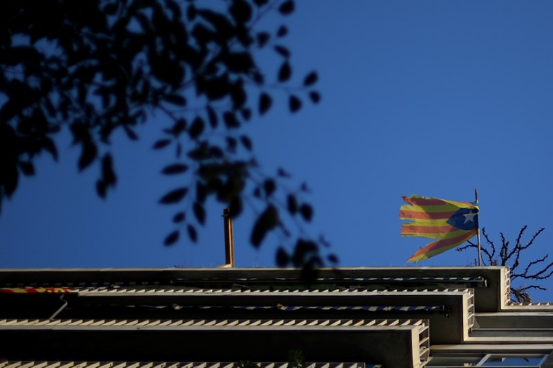 © Reuters. A damaged Estelada (Catalan flag of independence) hangs from a balcony in Barcelona