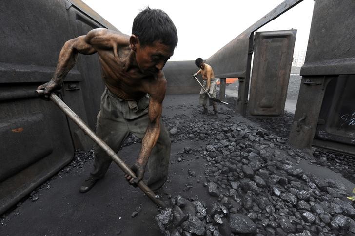 © Reuters. FILE PHOTO:  Workers unload coal at a storage site along a railway station in Hefei
