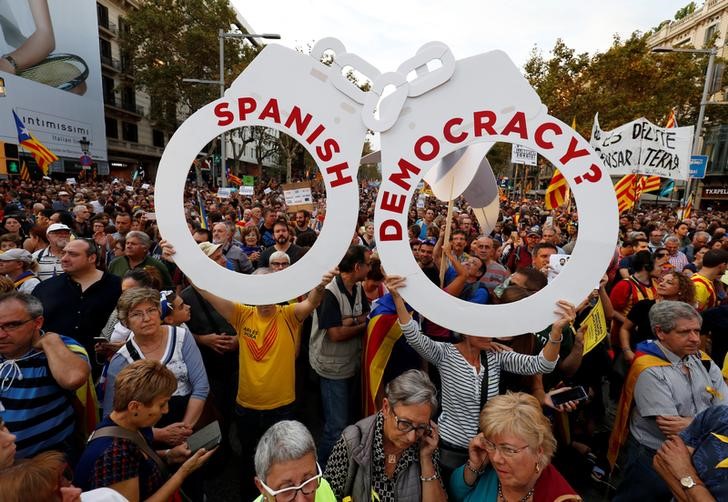 © Reuters. People hold a giant pair of handcuffs during a demonstration organised by Catalan pro-independence movements ANC (Catalan National Assembly) and Omnium Cutural, following the imprisonment of their two leaders, in