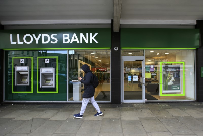 © Reuters. A man walks past a Lloyds Bank branch in central London