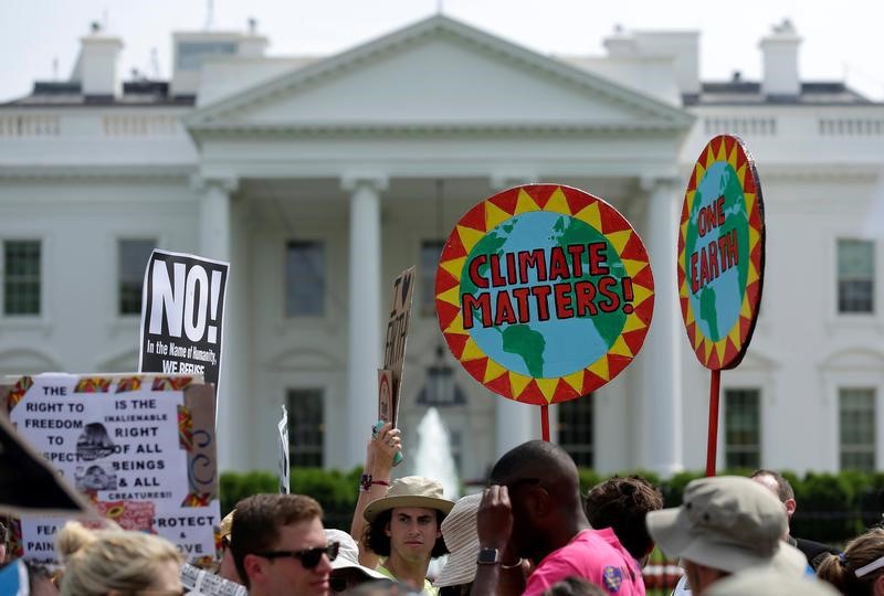 © Reuters. Protesters carry signs during the Peoples Climate March at the White House in Washington