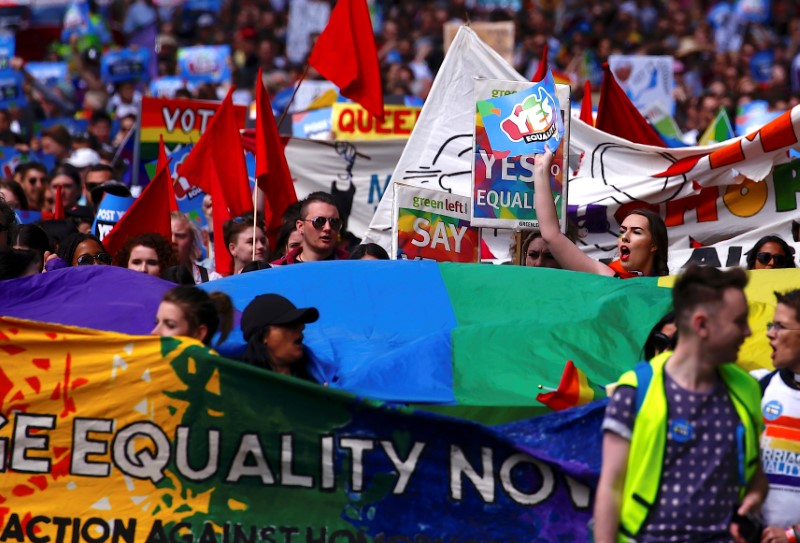 © Reuters. Marchers hold signs and banners as they participate in a marriage equality march in central Sydney