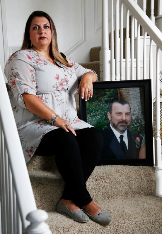 © Reuters. Farrah Fasold poses for a portrait with a painting of her late father Harold Dillard at her home in Flower Mound