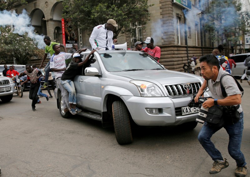 © Reuters. A photographer runs for cover after policemen fired tear gas at a convoy of opposition politicians and supporters of the National Super Alliance coalition during a protest along a street in Nairobi