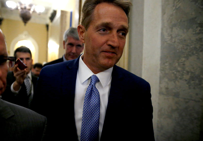 © Reuters. U.S. Senator Jeff Flake (R-AZ) walks past journalists after announcing he will not run for reelection on Capitol Hill in Washington