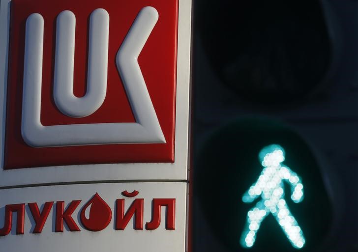 © Reuters. Светофор на фоне логотипа Лукойла