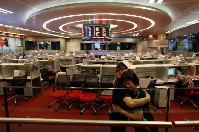 © Reuters. Catherine Cheung is hugged by her colleague before leaving the trading hall of the Hong Kong Exchanges in Hong Kong