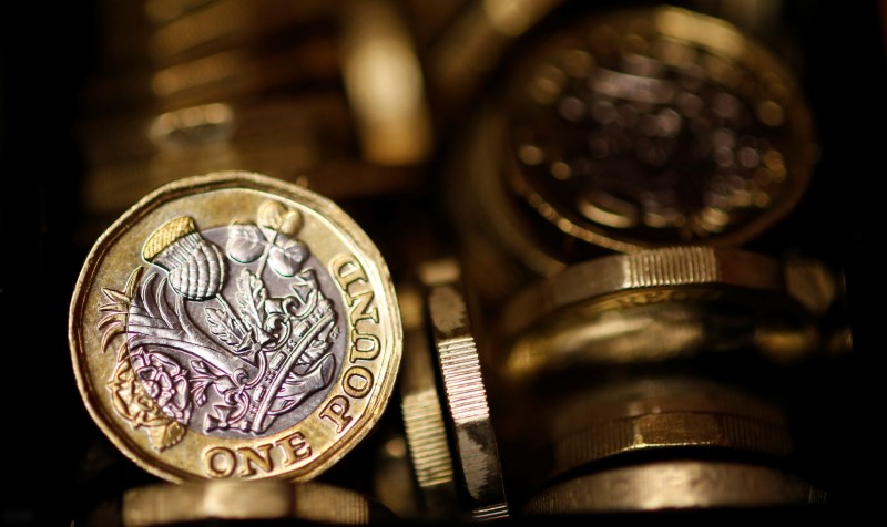 © Reuters. Pound coins are seen in this photo illustration taken in Manchester, Britain