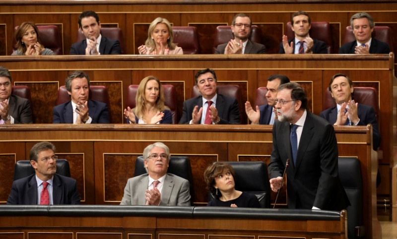 © Reuters. Spain's PM Rajoy is applauded by his fellow People's Party (PP) deputies during the weekly cabinet control session at Parliament in Madrid