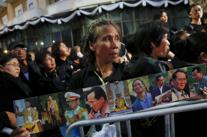 © Reuters. Mourners wait to go through security check for tomorrow's Royal Cremation ceremony of Thailand's late King Bhumibol Adulyadej near the Grand Palace in Bangkok