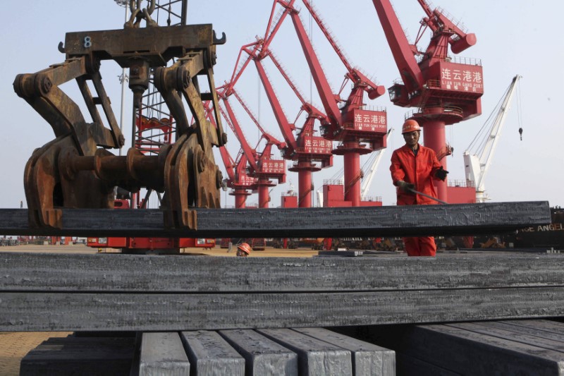 © Reuters. A worker loads steel bars for export at a port in Lianyungang