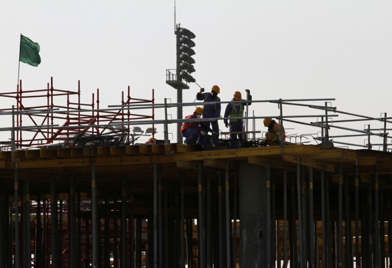 © Reuters. FILE PHOTO: Migrant labourers work at a construction site at the Aspire Zone in Doha