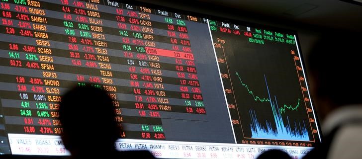 © Reuters. Pessoas olham para tela com índices de mercado na bolsa de valores, em São Paulo
