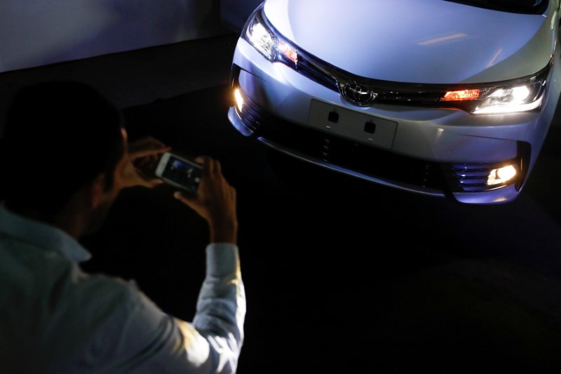© Reuters. A man takes a photo of a Toyota Motor Corp's Corolla car in Caracas