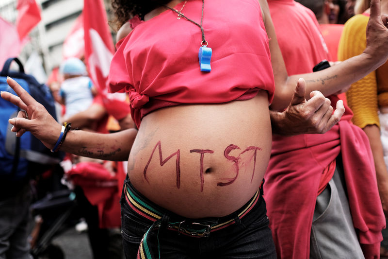 © Reuters. Pregnant woman shows her belly with the initials of Brazil's Homeless Workers' Movement (MTST) during a vote on whether the Congress allows charges against President Michel Temer to be sent to the Supreme Court for trial, in Sao Paulo