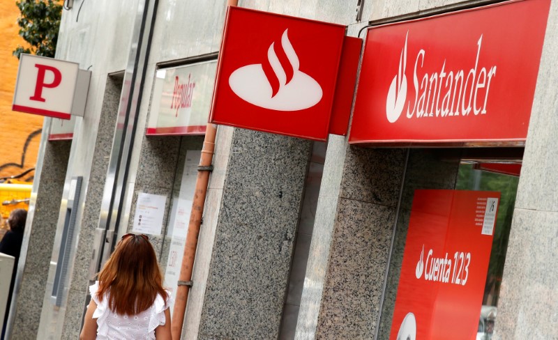 © Reuters. A woman walks past a Banco Popular and Santander banks offices in Barcelona