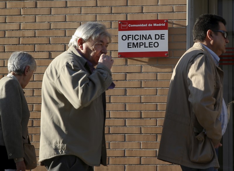 © Reuters. People stand in a line to enter a government employment office in Madrid