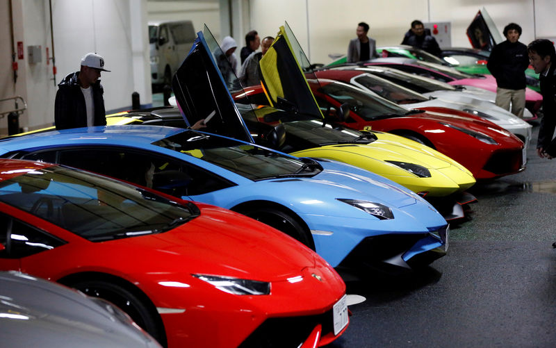 © Reuters. Supercar fans look at Lamborghini and Ferarri supercars during their meeting at the Umihotaru parking area in Kisarazu