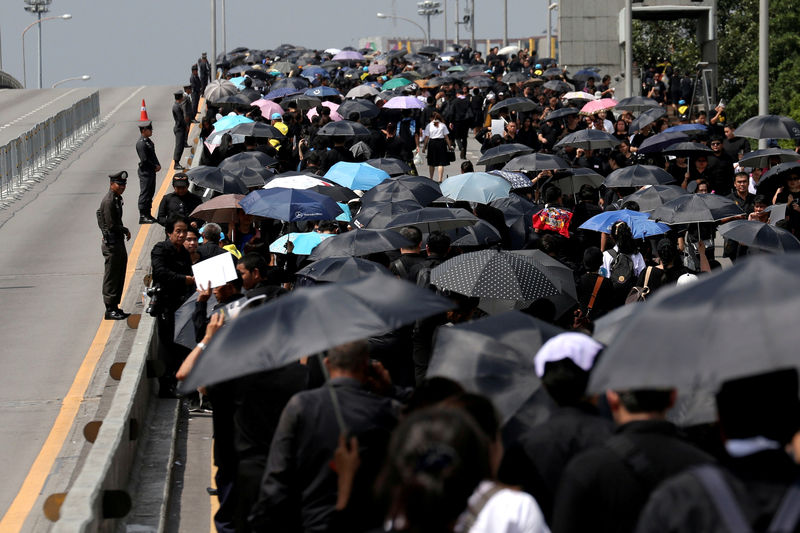 © Reuters. Pessoas andam em ponte após comparecerem ao funeral do falecido rei da Tailândia Bhumibol Adulyadej, em Bangcoc