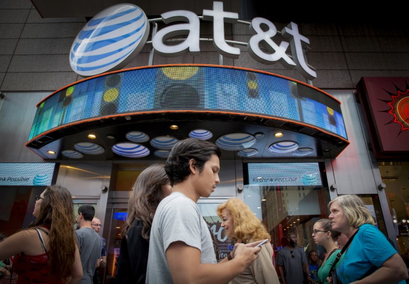 © Reuters. FILE PHOTO: People walk past the AT&T store in New York's Times Square in New York