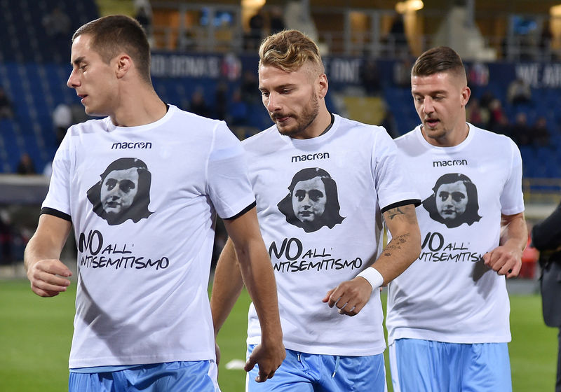 © Reuters. FILE PHOTO: Lazio's players Ciro Immobile, Adam Marusic and Sergej Milinkovic-Savic wear a shirt with a picture of Anne Frank before their Serie A soccer match against Bologna at the Dall'Ara stadium in Bologna