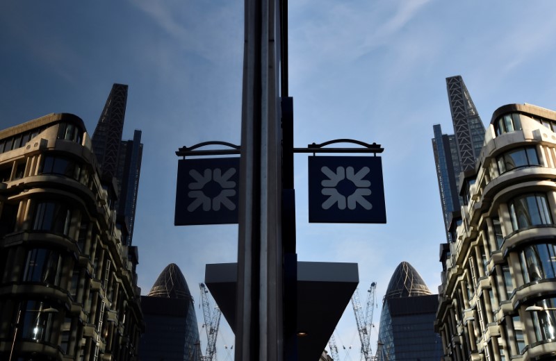 © Reuters. FILE PHOTO -  A logo at a branch of the Royal Bank of Scotland is seen reflected in a window in the City of London