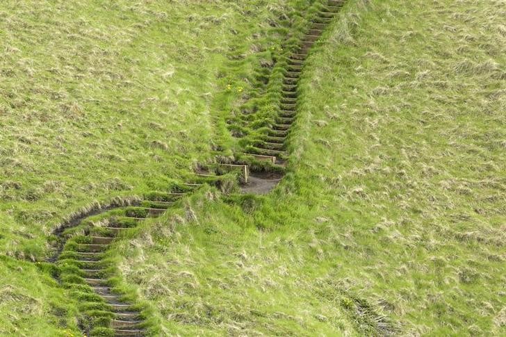 © Reuters. A staircase cut into the grass rises up a hillside in Skogarfoss, Iceland