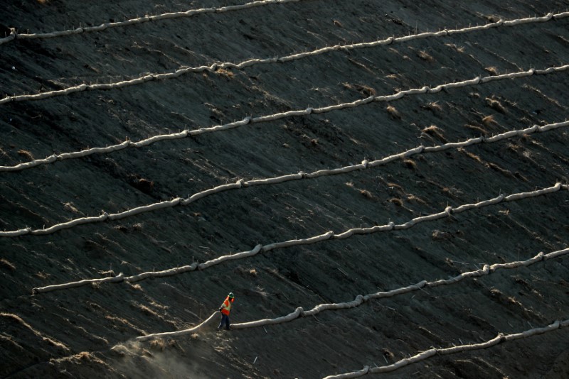 © Reuters. A construction worker works on the side of a hill along a highway construction project in Encinitas