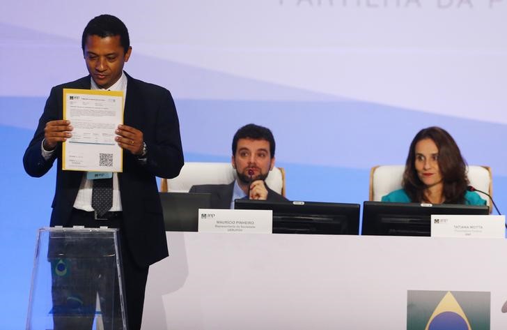 © Reuters. Davilson Andrade, representante da Statoil, deposita envelope durante leilão do pré-sal no Rio de Janeiro