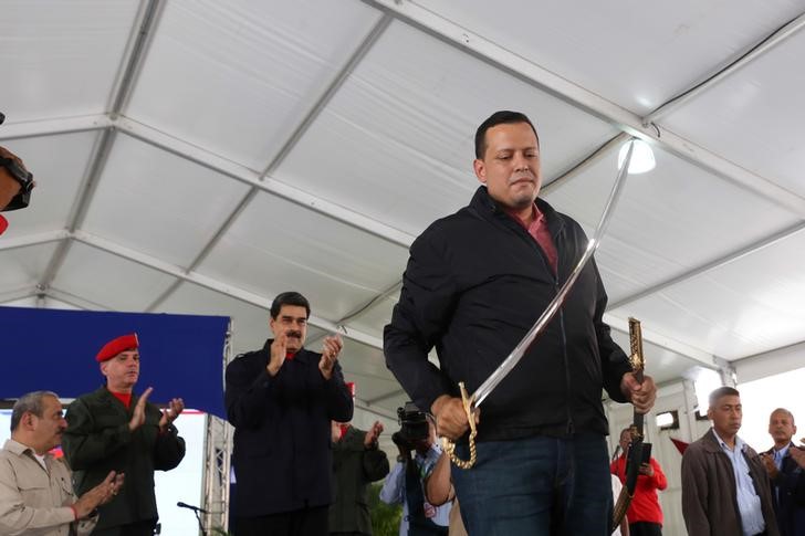 © Reuters. Simon Zerpa, vice president for finance at PDVSA, holds a replica of the sword of national hero Simon Bolivar next to Venezuela's President Nicolas Maduro during a ceremony in Caracas