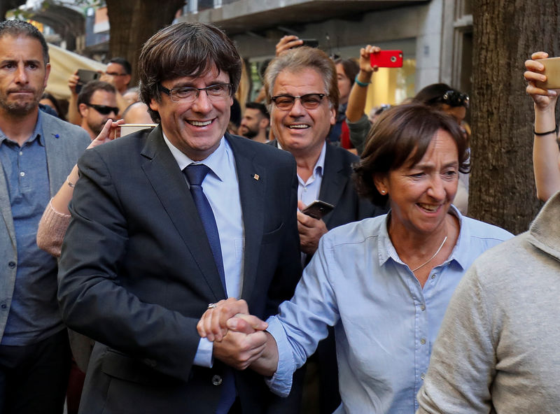 © Reuters. Sacked Catalan President Carles Puigdemont greets a supporter after leaving a restaurant the day after the Catalan regional parliament declared independence from Spain in Girona